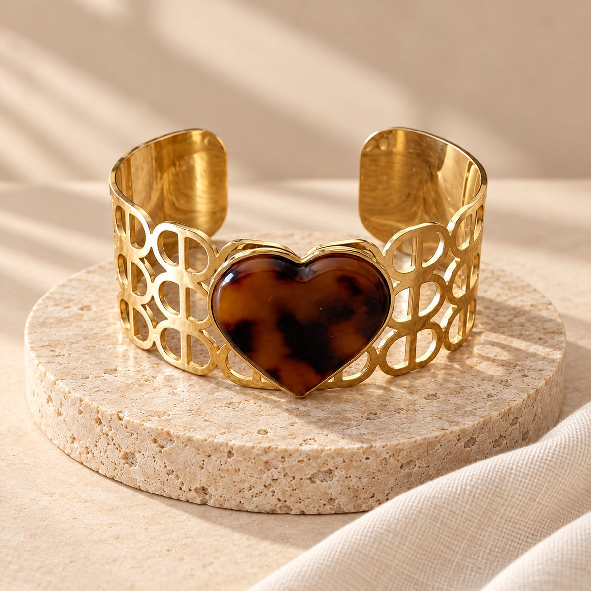 Brazalete Corazón Animal sobre piedra beige, con el corazón de estampado animal y la banda calada