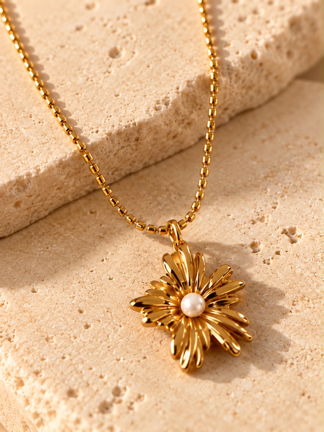 Colgante de flor dorada con perla del Collar Flor Perla sobre piedra beige