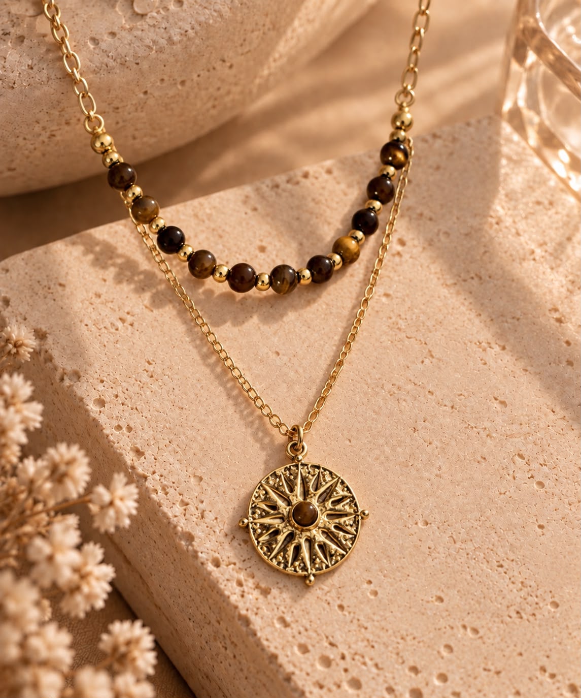 Collar Sol de Tigre con medallón de sol y cuentas de ojo de tigre sobre piedra beige