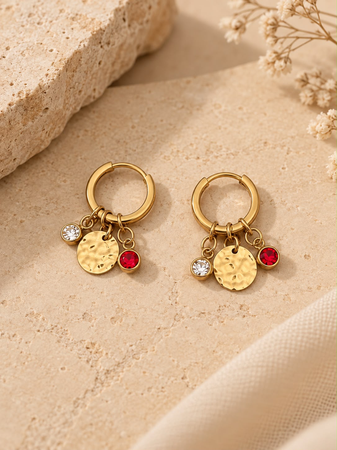 Pendientes Carmesí sobre piedra beige: aro dorado con medalla martilleada y colgantes transparente y rojo